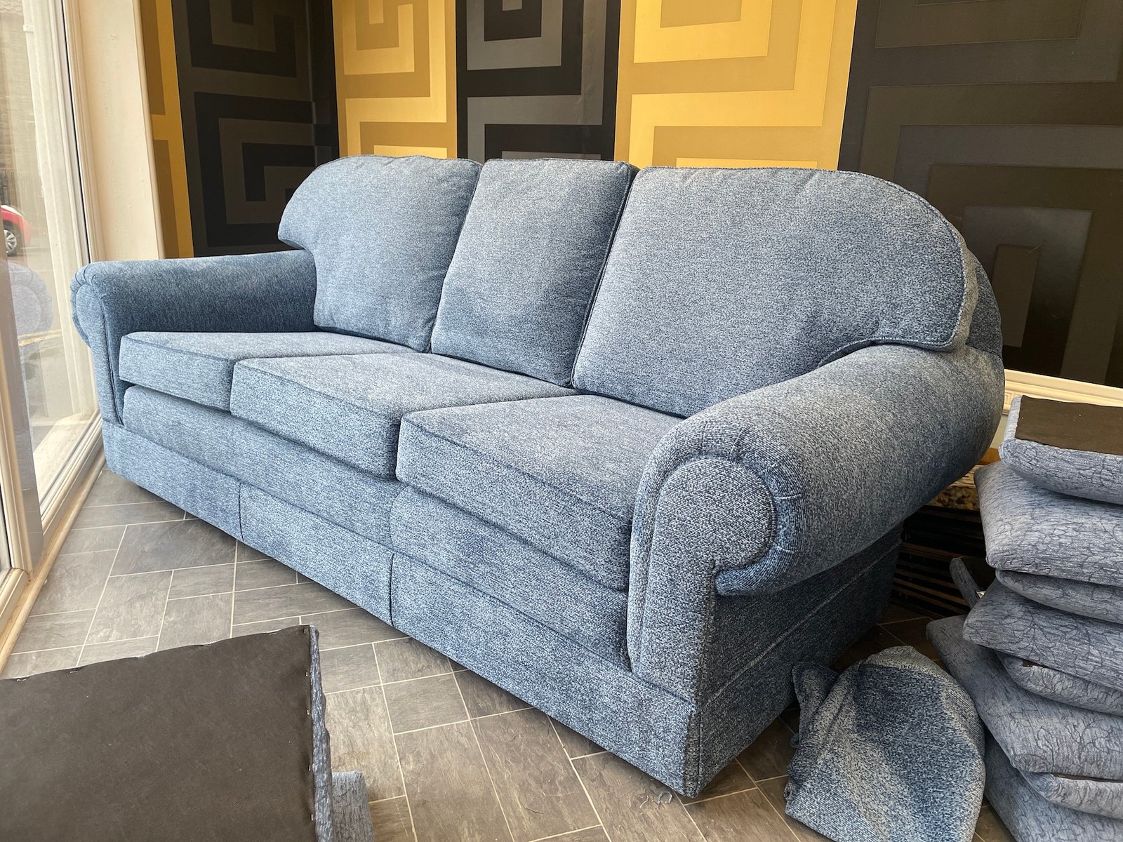 Rounded grey three-seat sofa with plush arms