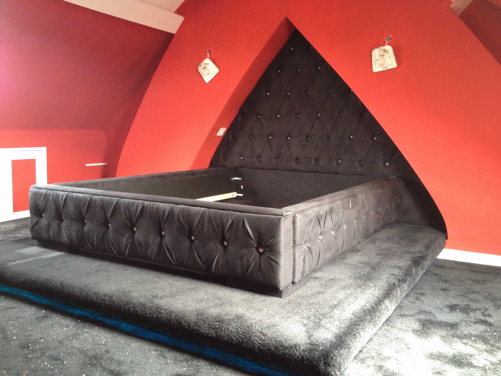 Finished upholstered bed beneath a triangular headboard