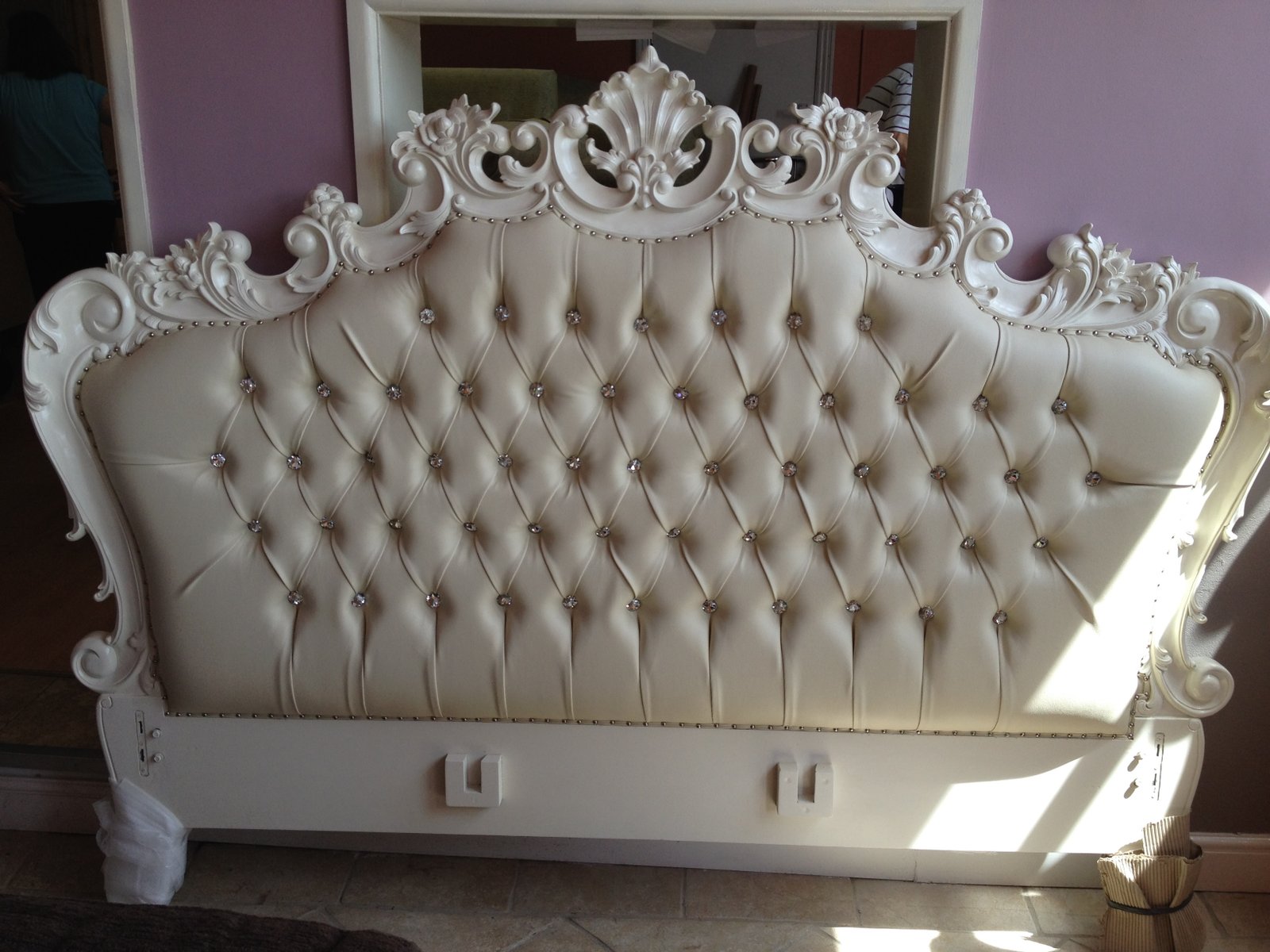 Ornate cream buttoned bed and headboard with carved detailing