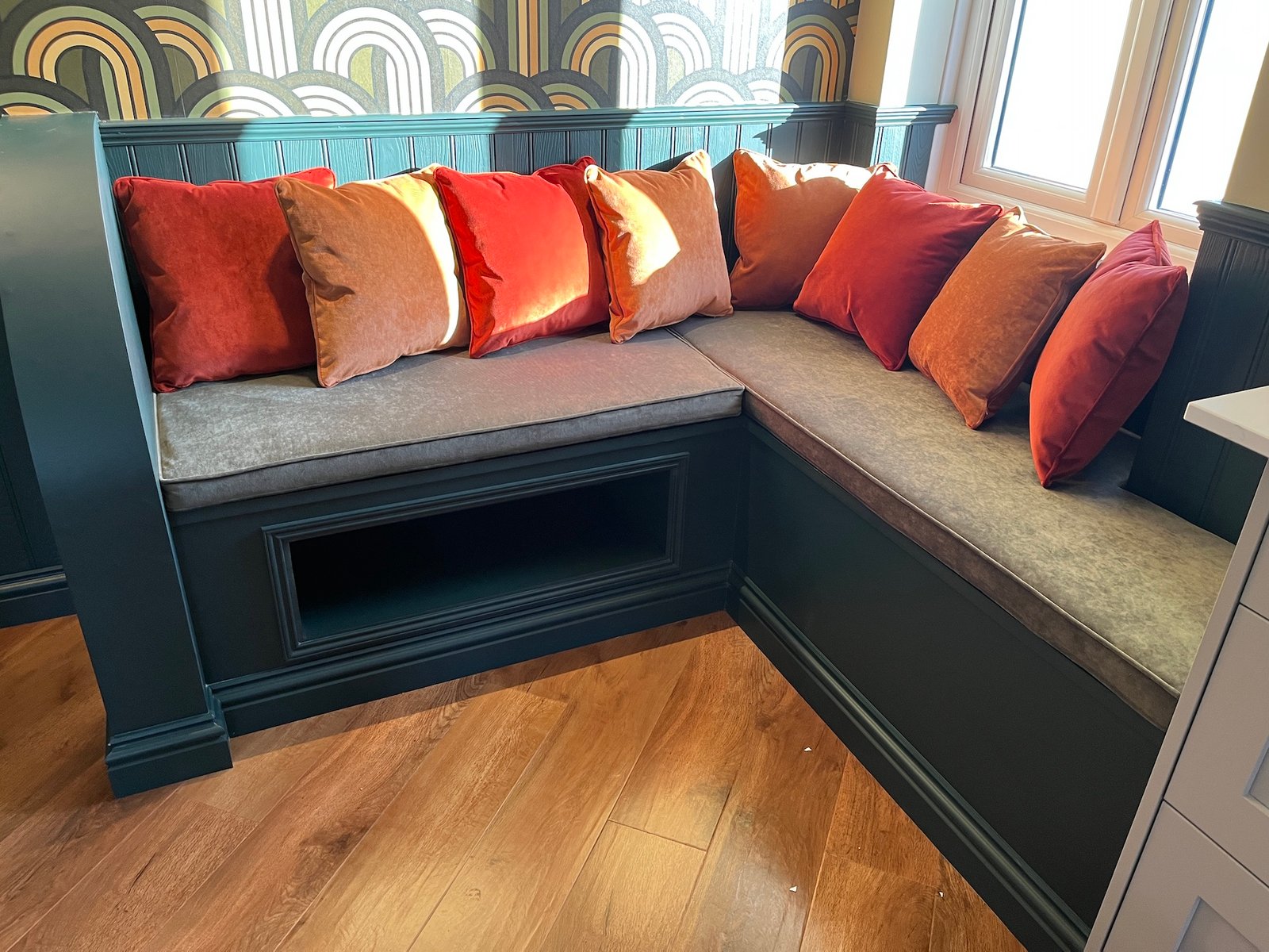 Grey corner seating with orange cushions in a domestic room