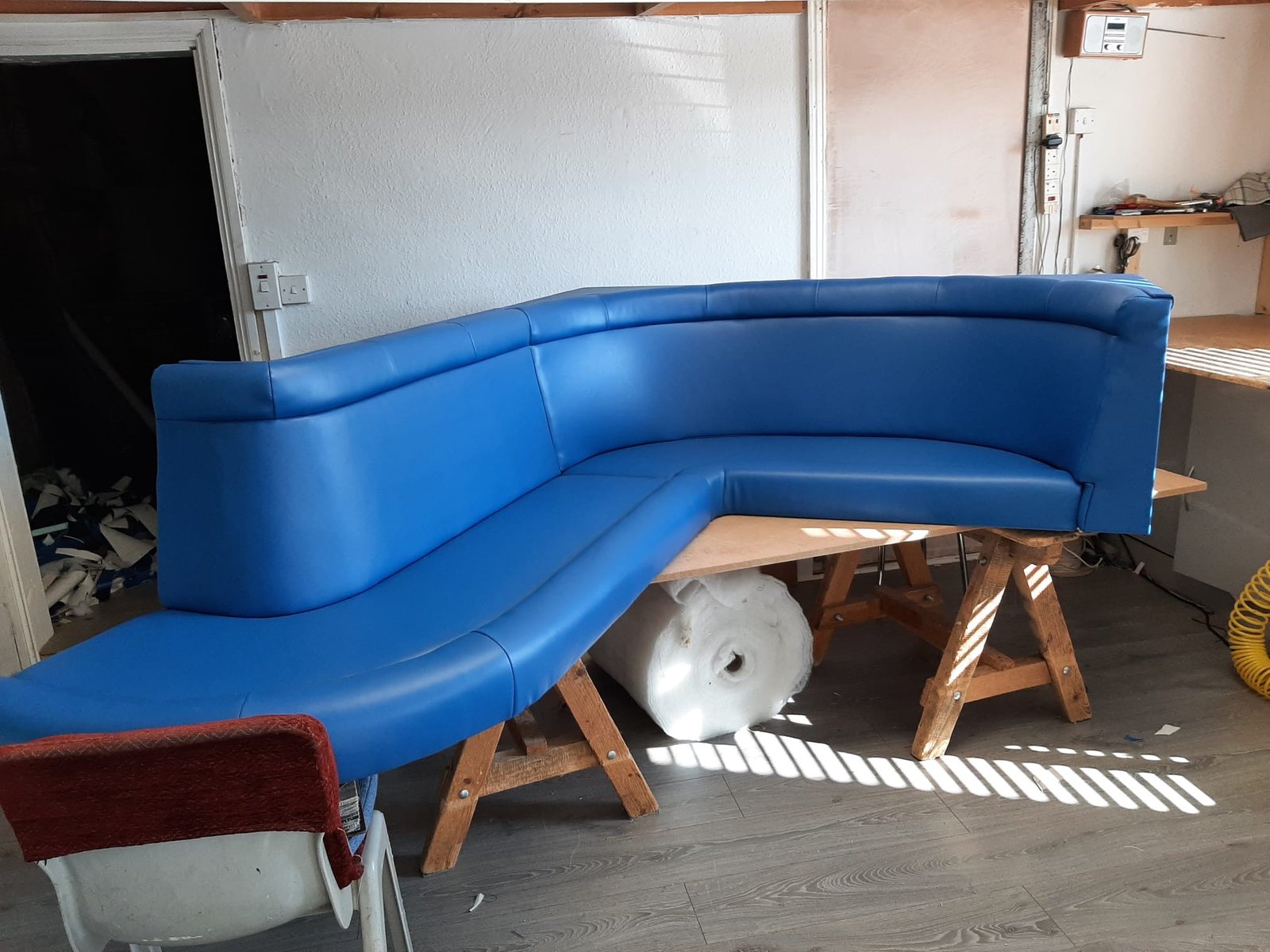 Curved blue bench or settee on workshop stands