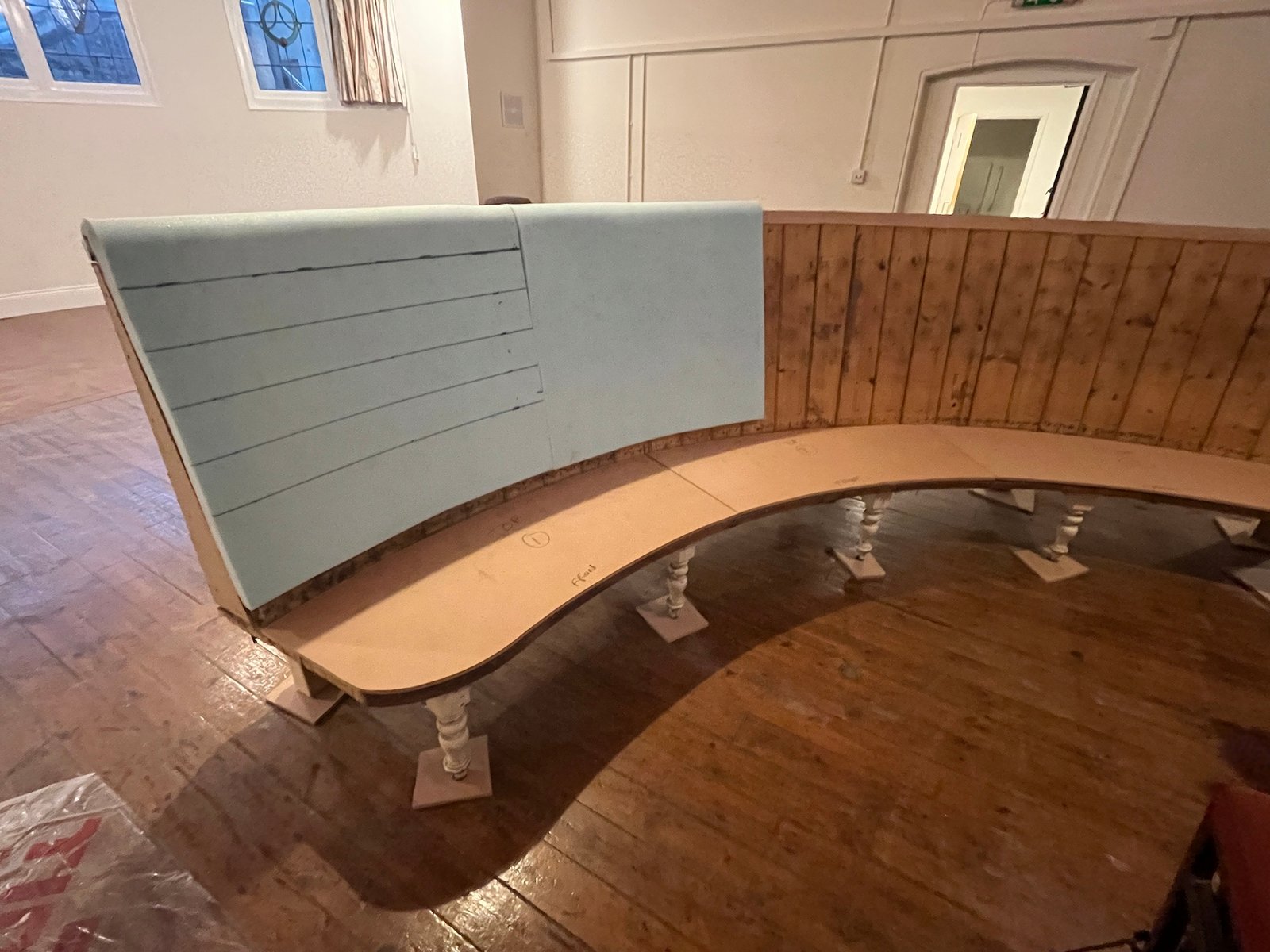Curved banquette with teal and brown upholstered backs