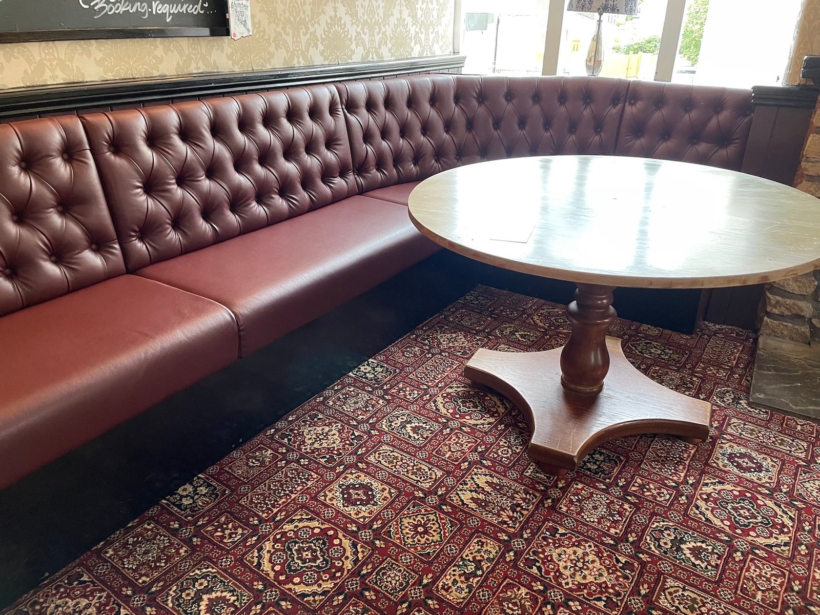 Burgundy buttoned restaurant booth with tables set