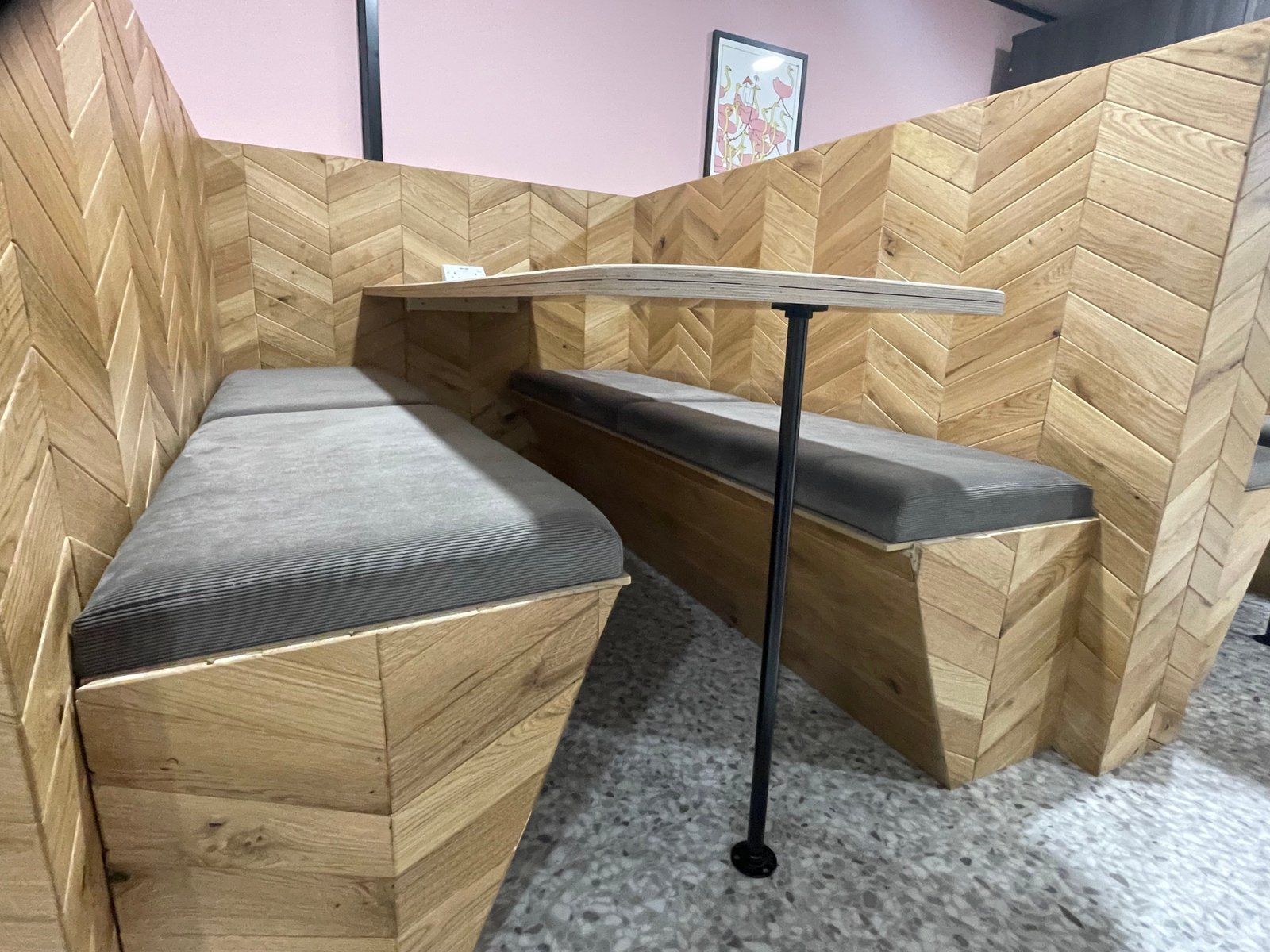 Herringbone timber booth with dark cushions and table