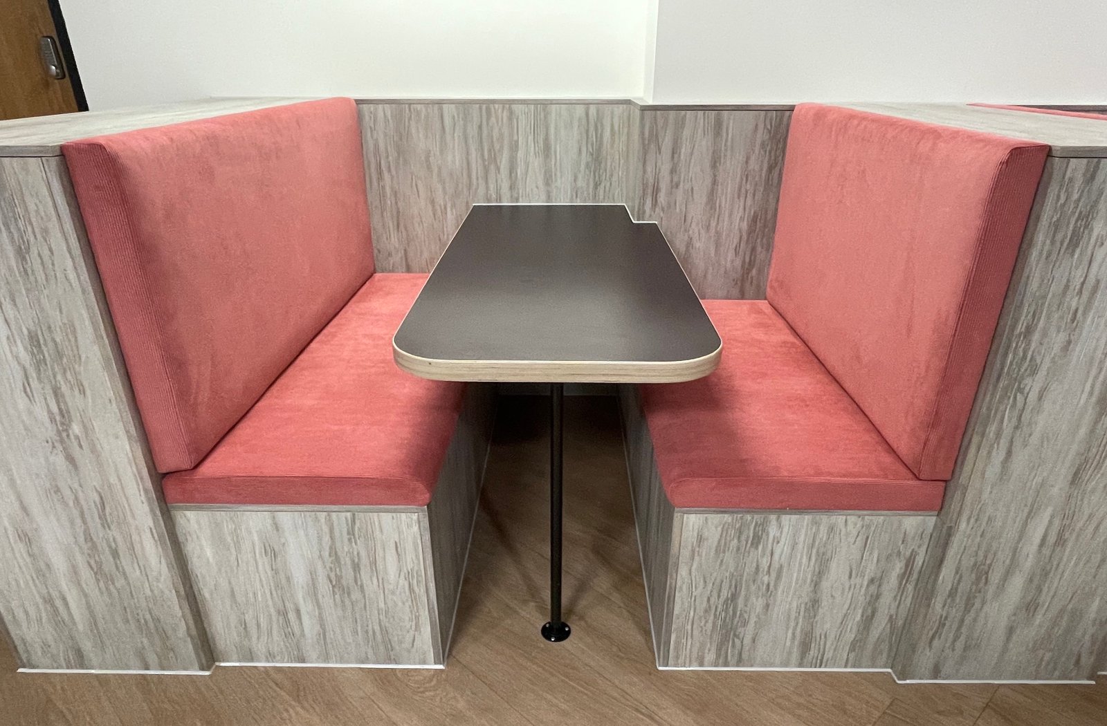 Restaurant booth with pink seats and grey partitions